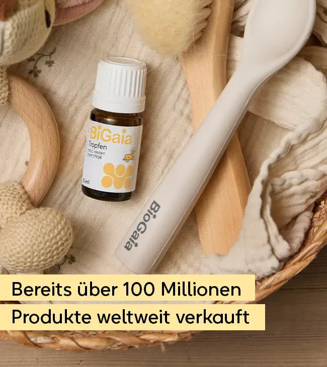 Nahaufnahme eines BiGaia Fläschchens neben einem Babylöffel und einer weichen Haarbürste in einem Körbchen. Text: Bereits über 100 Millionen Produkte weltweit verkauft.