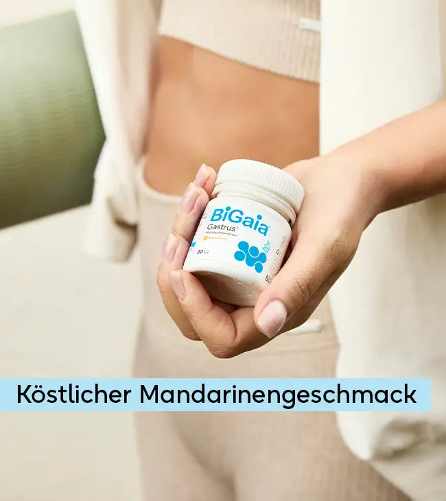 Eine Person hält die BiGaia Gastrus Dose in der Hand. Im Vordergrund steht der Text: Köstlicher Mandarinengeschmack.