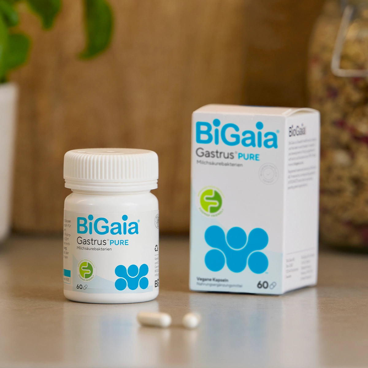 BiGaia Gastrus Pure Packung und Dose für vegane Kapseln mit dem "FODMAP Friendly" Siegel auf einer Arbeitsplatte.