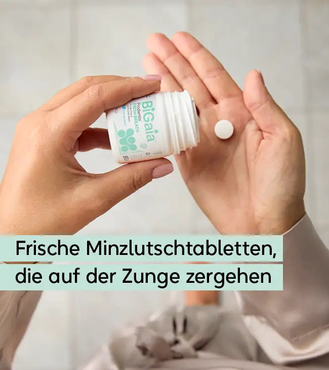 Nahaufnahme einer Hand, die eine weiße BiGaia Prodentis Lutschtablette aus der Dose auf die Handfläche gibt. Text: Frische Minzlutschtabletten, die auf der Zunge zergehen.
